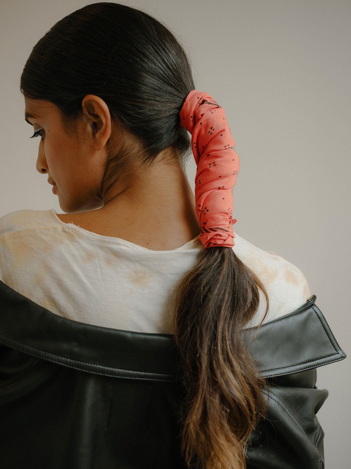 Ponytail with SUNDAY/MONDAY's coral Constellation bandana, featuring a delicate black block print pattern.